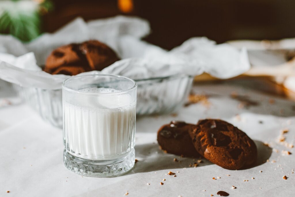 Close-up of glass with milk and chocolate cookies, perfect for dessert themes.